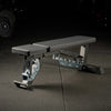 Adjustable weight bench on a dark floor with gym equipment in the background
