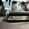 Close-up of a gym bench with a textured grip and a bolt, blurred background