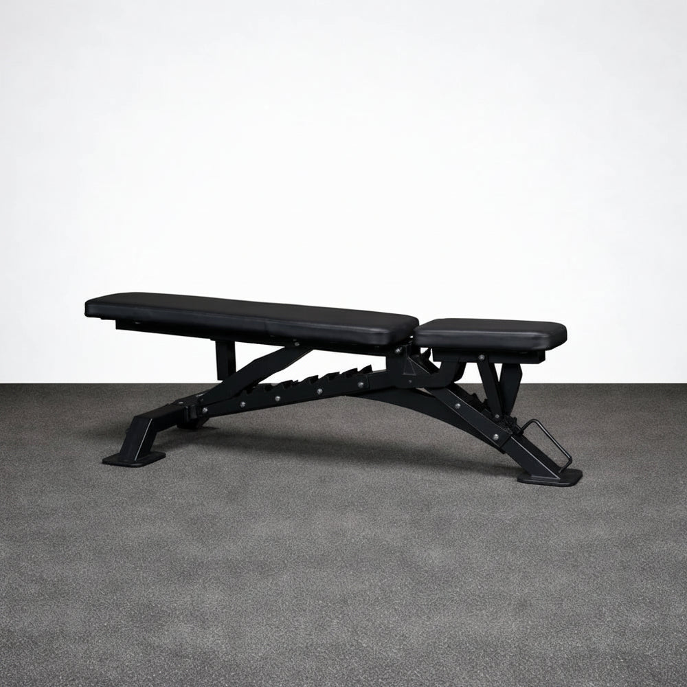 Black adjustable weight bench on a gray floor with a white wall background