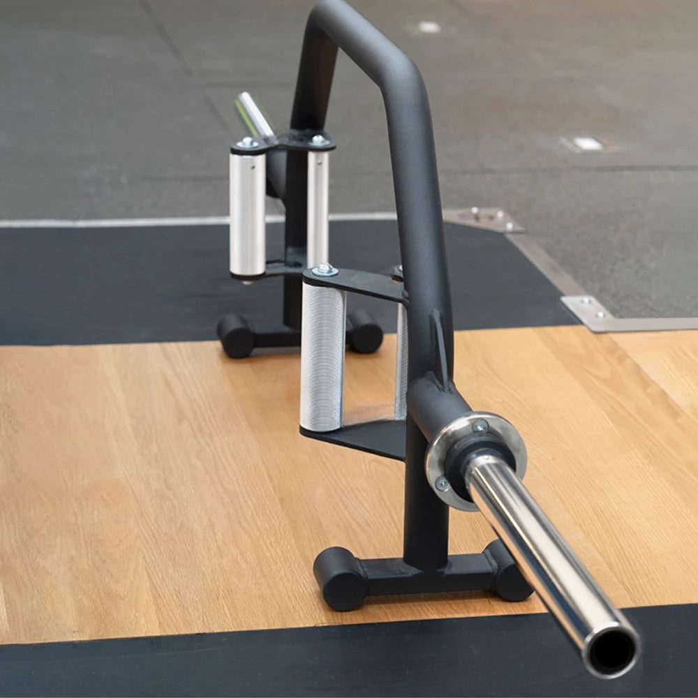 Barbell on a weight rack with a gym floor in the background