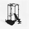 Black weightlifting cage with bench and weight plates on a white background