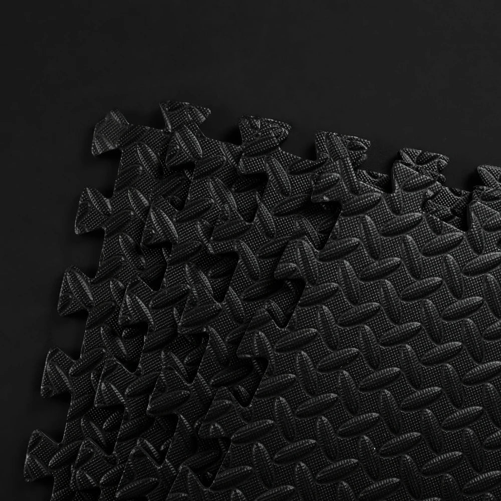Stack of black textured mats on a dark background