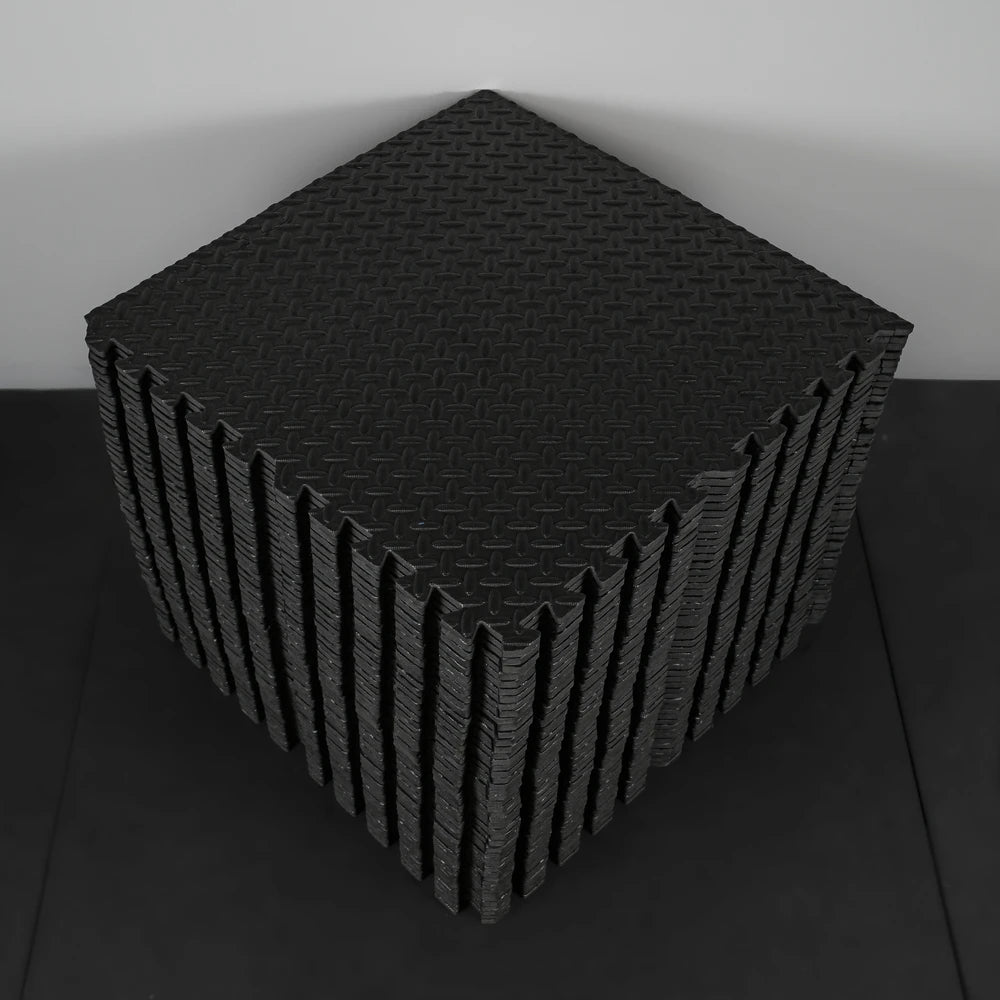 Black foam puzzle mat on a black surface with a white background
