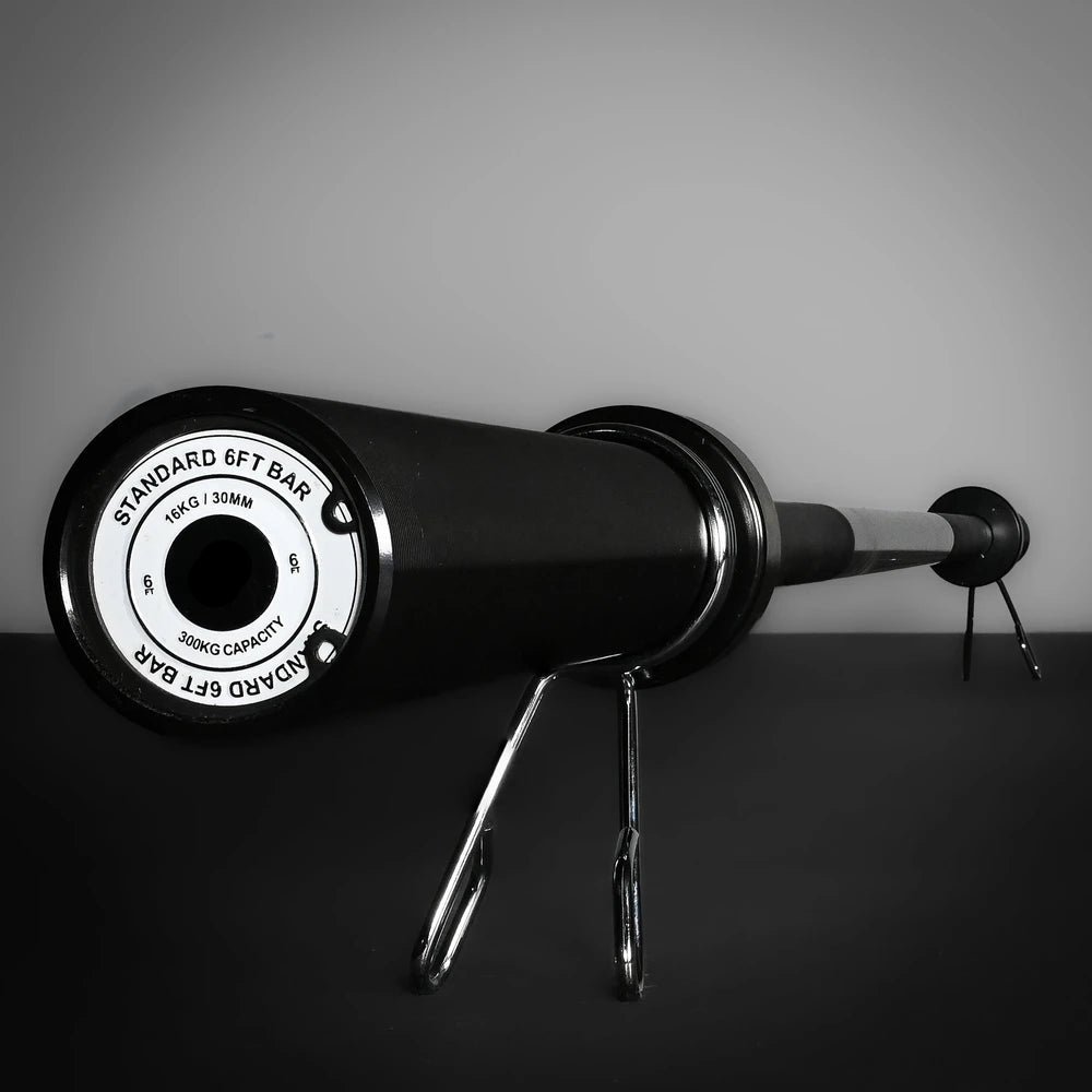 Gym bar with weight plates on a dark surface and gray background