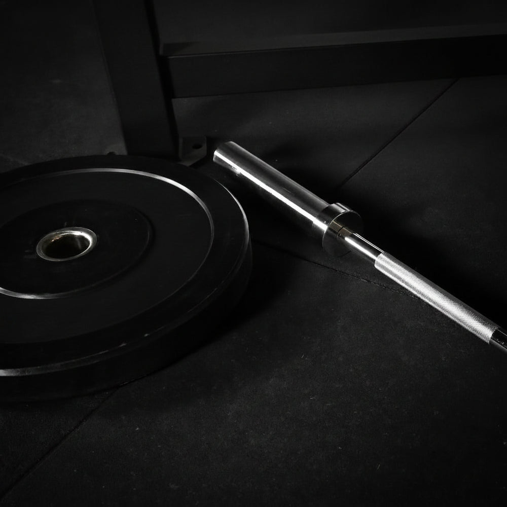 Barbell with weight plates on a dark floor