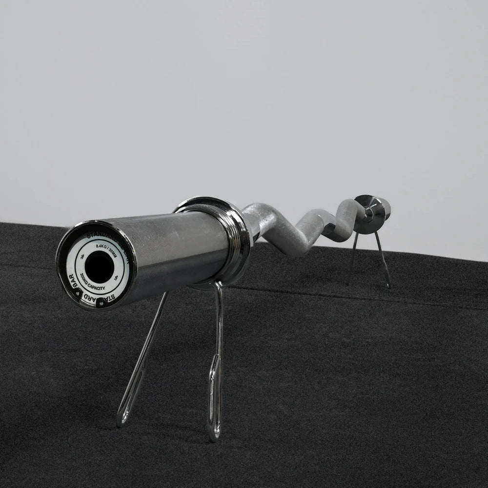 Metallic barbell  on a black surface with a gray background