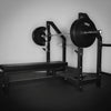 Gym equipment including a barbell with weights on a squat rack and bench.