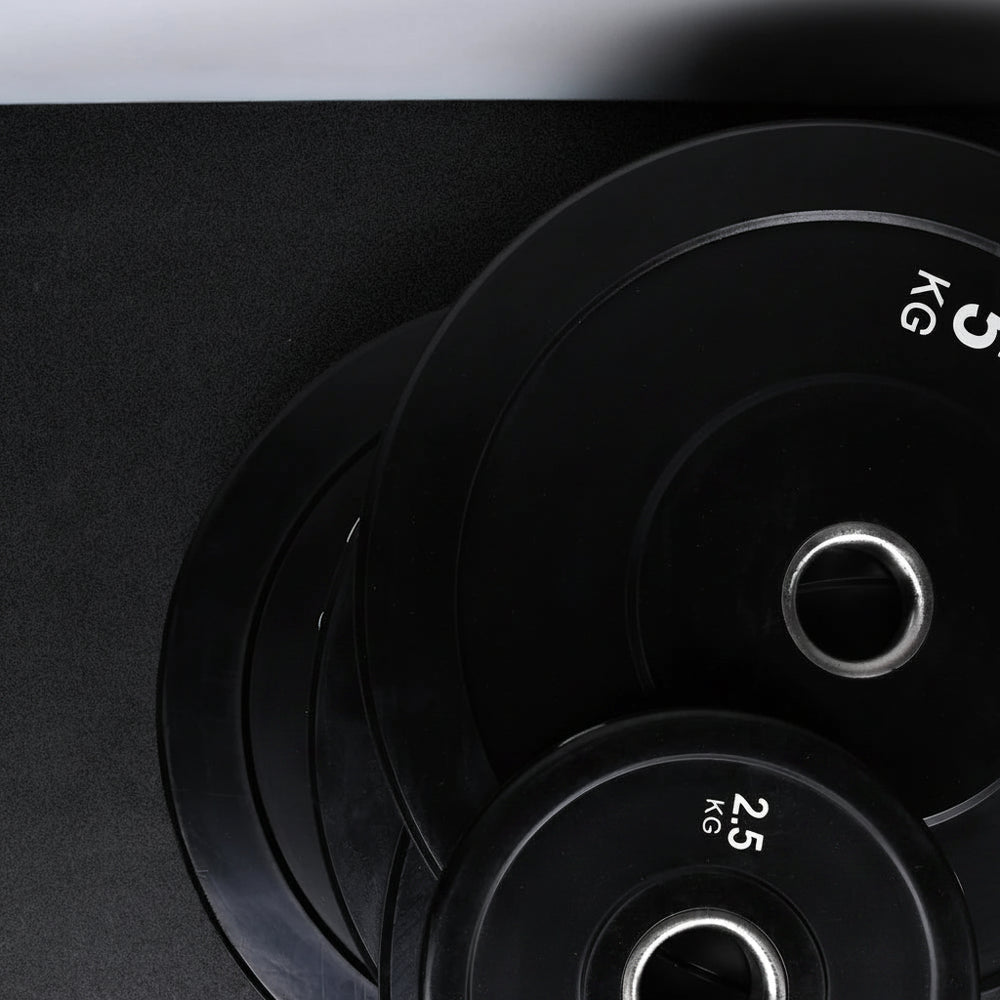 Stack of black weight plates on a dark background