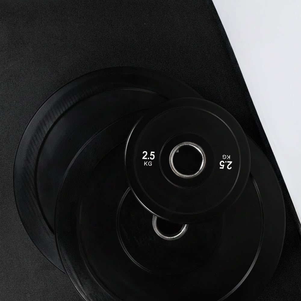 Black weight plates with white text and branding on a black background