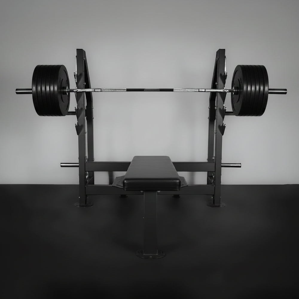 Barbell with weights on a weight rack against a plain wall.