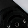 Stack of black weight plates on a dark background