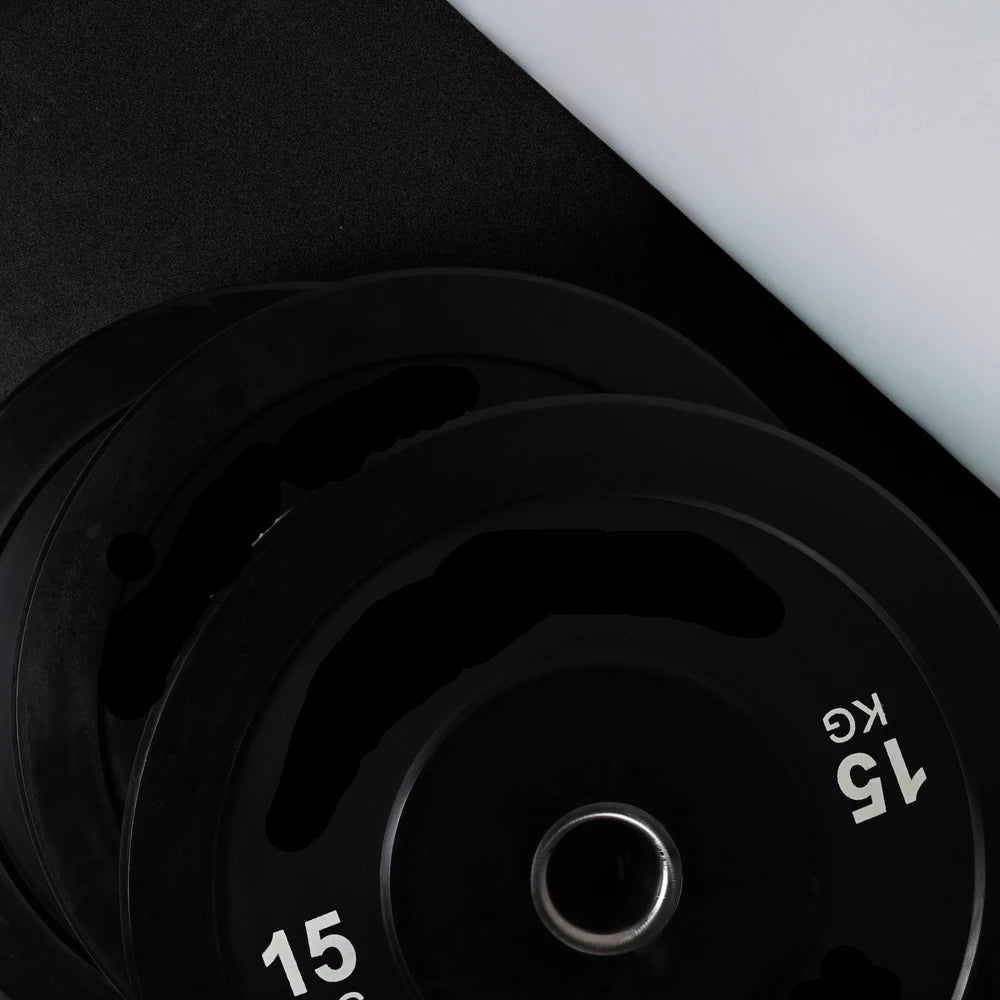 Stack of black weight plates on a dark background