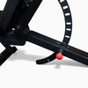 Close-up of a black exercise bike with a red button on a white background