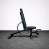 Black weight bench on a gray floor with a white background