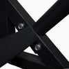 Close-up of a black metal frame with screws on a white background