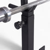 Close-up of a weightlifting bar attached to a black support structure with a white background.
