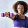 Woman holding a purple dumbbell against a light gray background