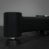 Close-up of a black metal component on a textured surface with a blurred background
