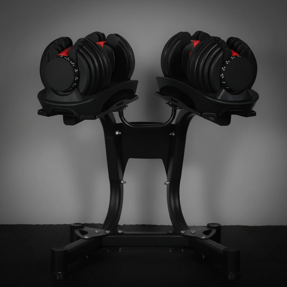 Pair of adjustable dumbbells on a stand against a dark background