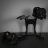 Pair of adjustable dumbbells on a stand against a dark background