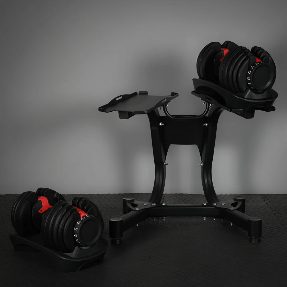 Pair of adjustable dumbbells on a stand against a dark background