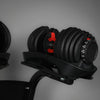 Pair of adjustable dumbbells on a stand against a gray background