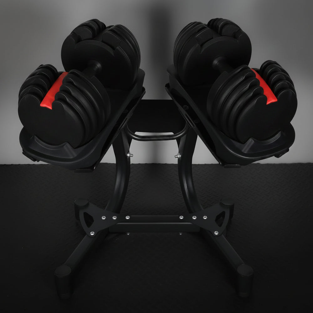 Pair of adjustable dumbbells on stands against a dark background