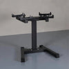 Black weight plate stand on a gray floor with a neutral background