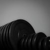 Set of black dumbbells with weight markings on a gray background