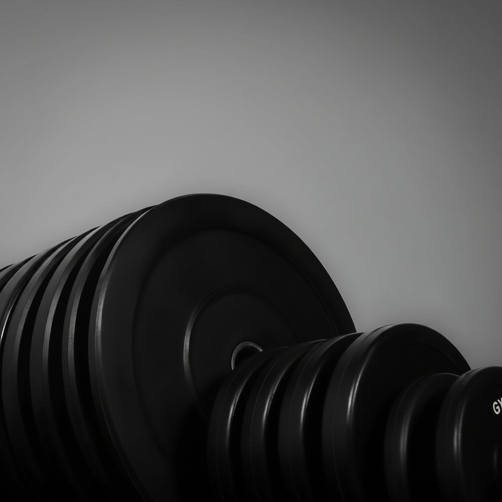 Set of black dumbbells with weight markings on a gray background