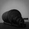 Set of gym weights including plates and dumbbells on a stand.