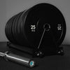 Set of weight plates with a barbell on a dark surface