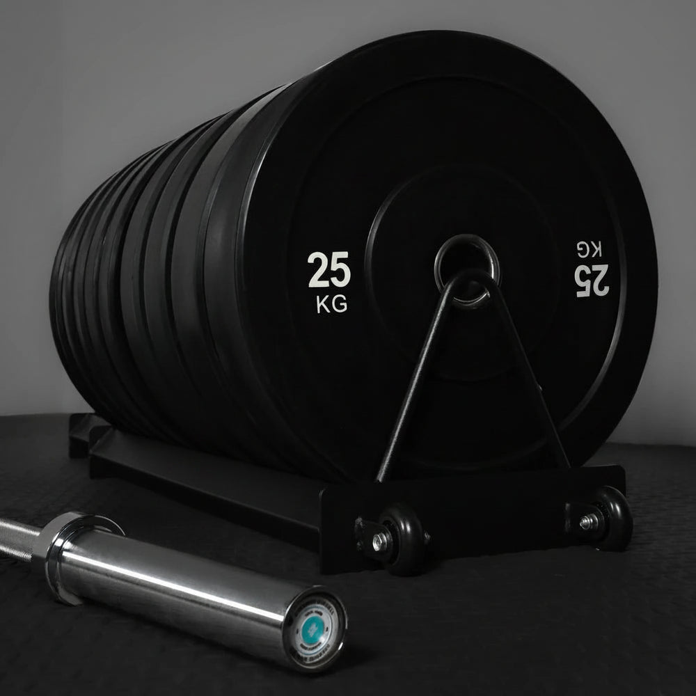 Set of weight plates with a barbell on a dark surface