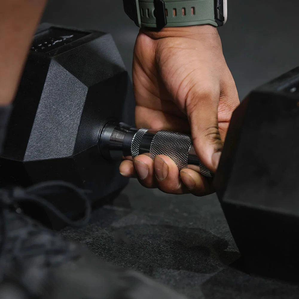 Hand holding a dumbbell with a blurred background