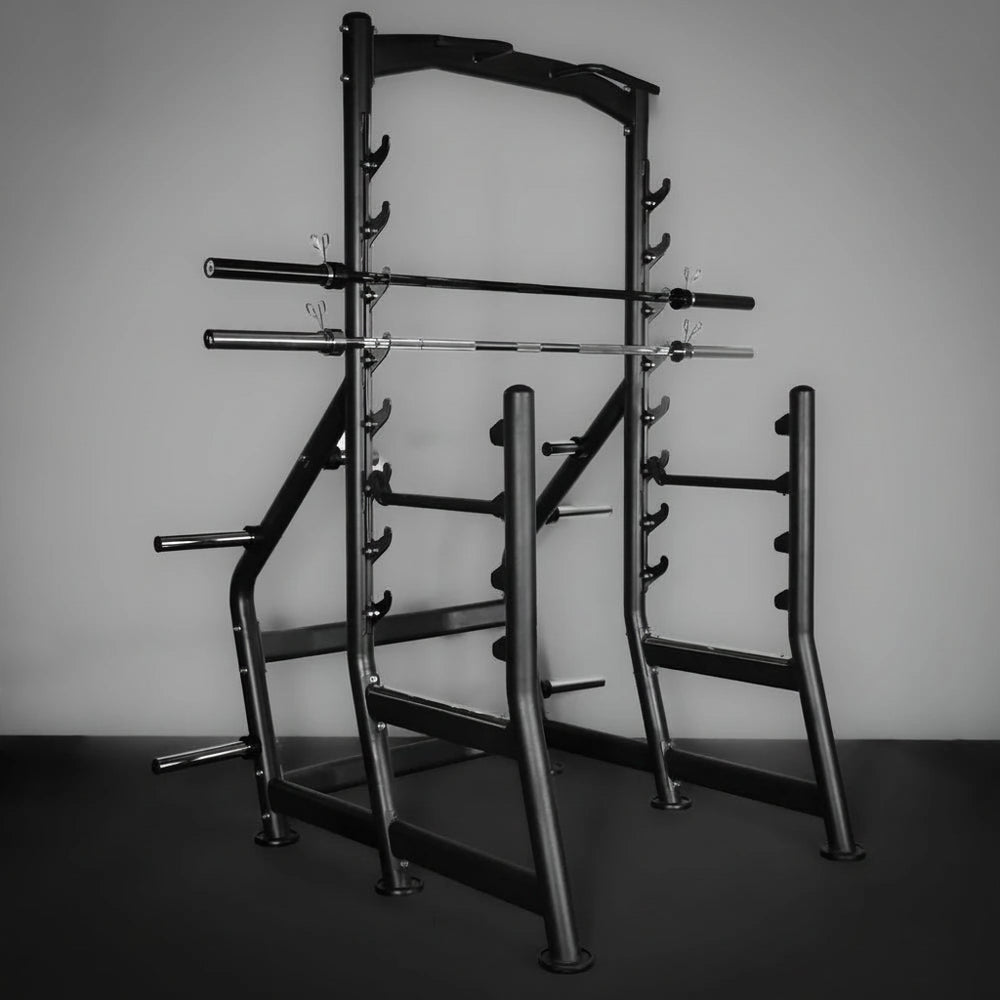 Gym rack with multiple barbells on a dark floor and light gray wall