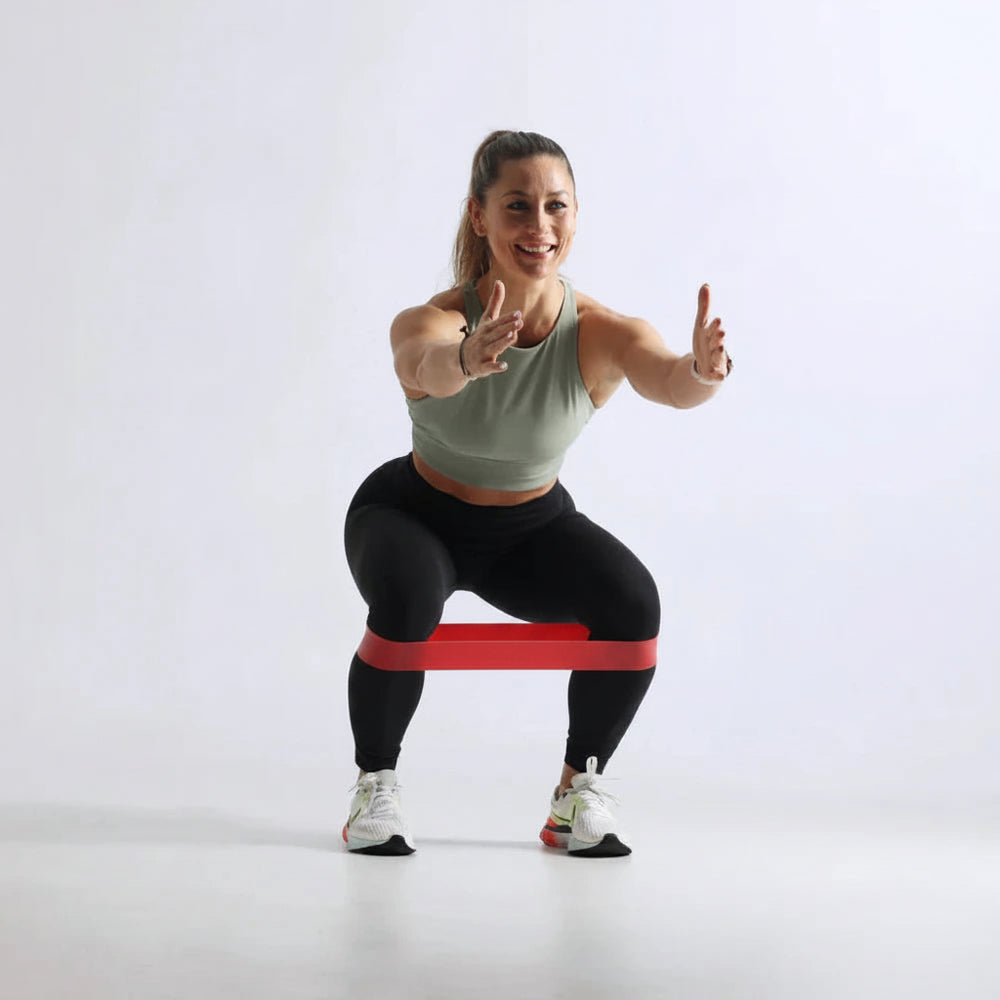 Woman exercising with a resistance band on a white background