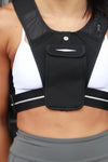 Person wearing a black athletic vest with a logo on a blurred background