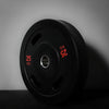 Black gym weight plate with red text on a gray background