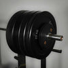 Black weight plate set on a barbell against a gray background