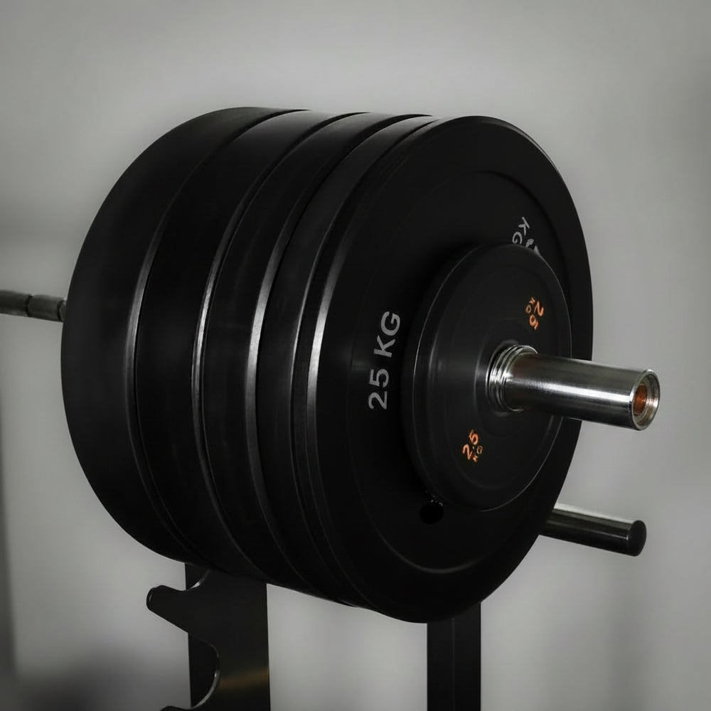 Black weight plate set on a barbell against a gray background
