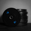 Stack of black weight plates on a dark background