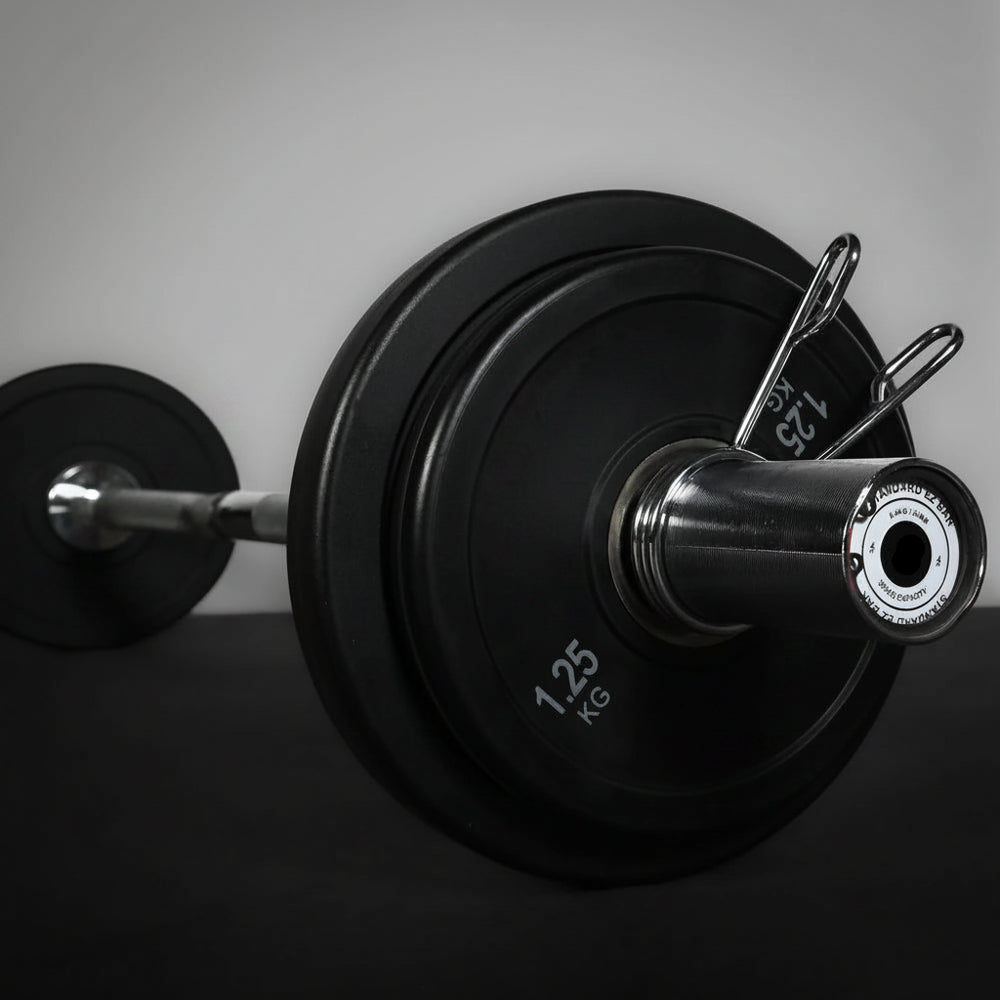 Close-up of a barbell with weight plates on a gray background