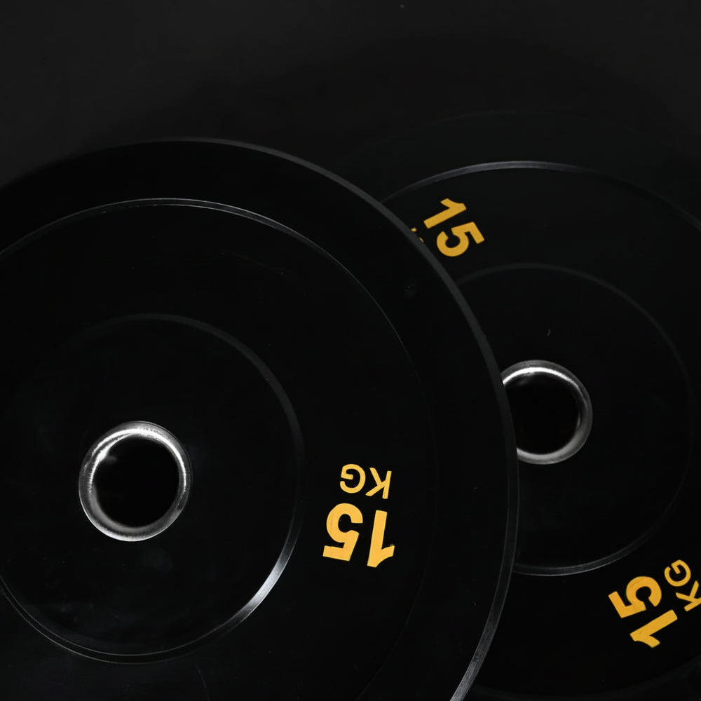 Two black weight plates with yellow text on a black background