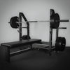 Weight bench with barbell and weights on a gray background