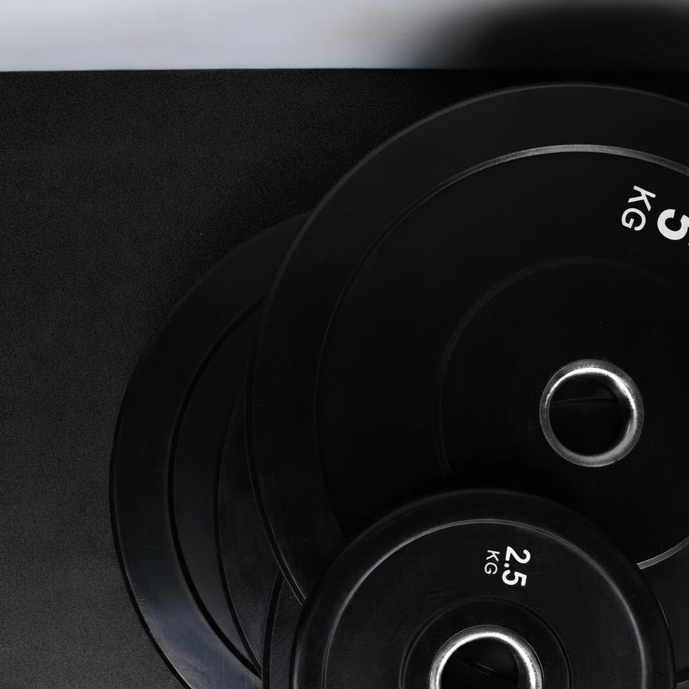 Stack of black weight plates on a dark background