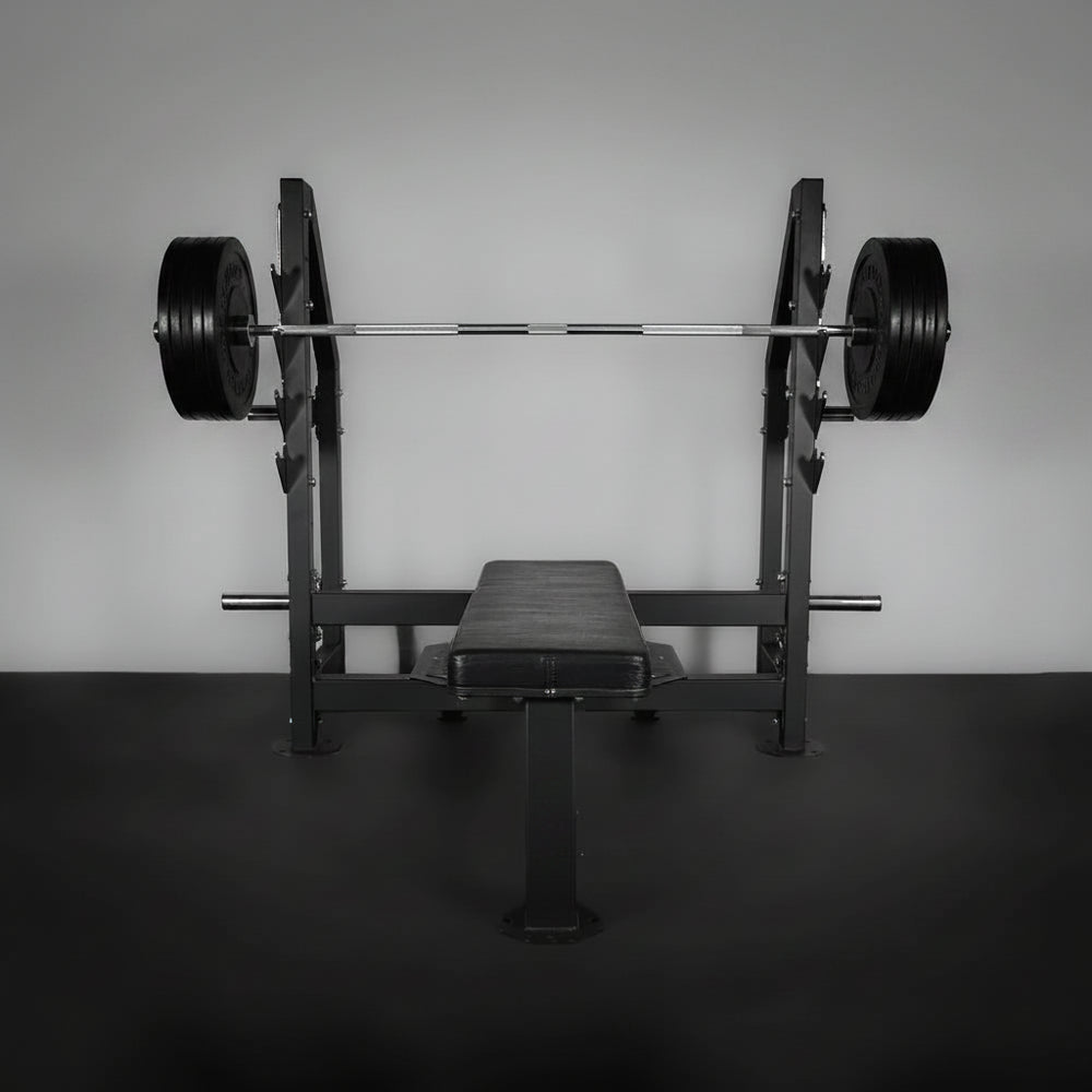 Barbell with weights on a weight rack against a plain wall.