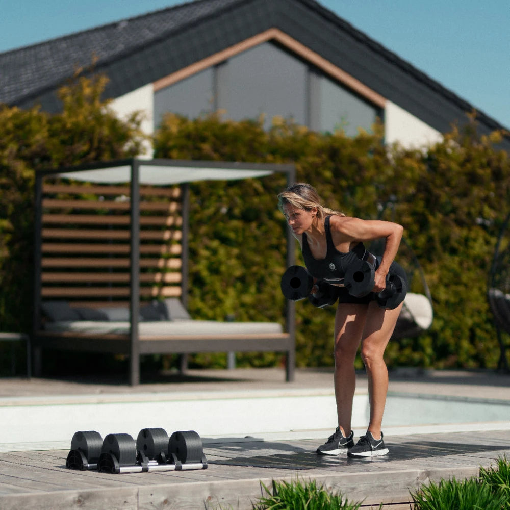 Woman exercising with dumbbells outdoors on a patio