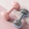 Two dumbbells, one pink and one gray, on a light pink background.