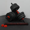 Black and red adjustable dumbbells set on a dark surface with a gray background