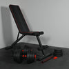Black adjustable weight bench with weights on a gray surface
